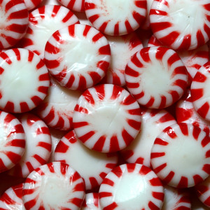 Pile of red-and-white striped round peppermint candies — scent inspiration for Peppermint fragrance oil