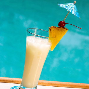 Creamy cocktail with pineapple wedge, cherry, blue umbrella — scent inspiration for Pina Colada Paradise fragrance oil