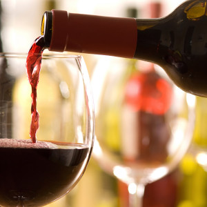 Red wine pouring from bottle into a glass — scent inspiration for Cabernet Sauvignon fragrance oil