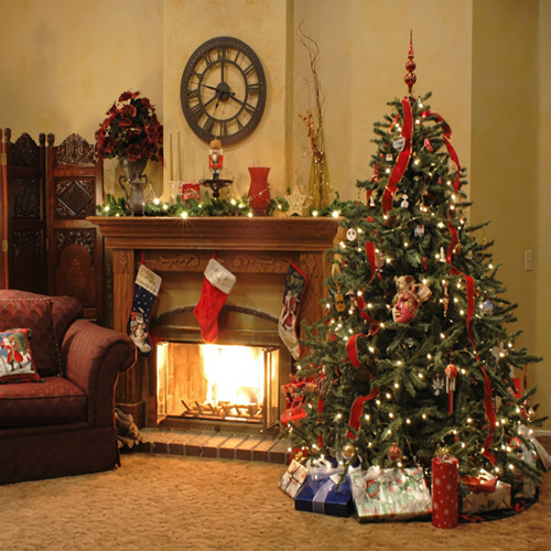 Lit Christmas tree and fireplace with stockings in a room — scent inspiration for Home for the Holidays fragrance oil