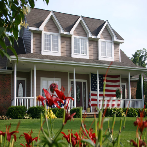 Two-story house with a front porch and American flag — scent inspiration for Home Sweet Home fragrance oil