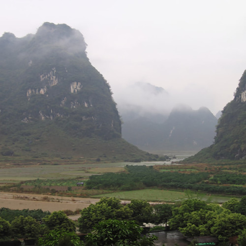 Misty green karst mountains over a river valley — scent inspiration for China Rain fragrance oil