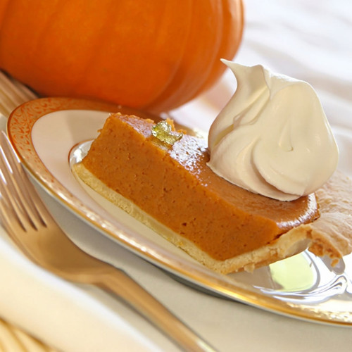 Slice of pumpkin pie with whipped cream, pumpkin behind — scent inspiration for Pumpkin Pie Spice fragrance oil