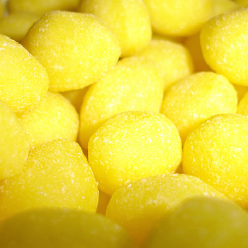 Pile of sugar-coated yellow candy drops — scent inspiration for Lemon Drop fragrance oil