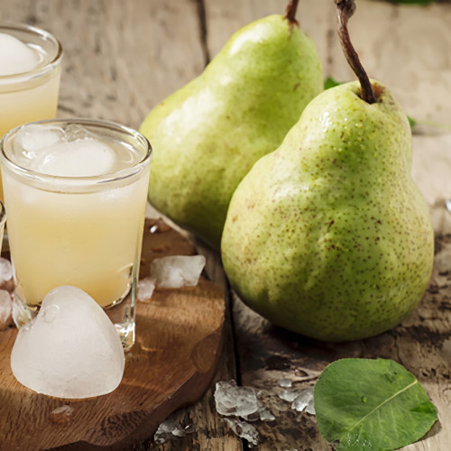Two green pears and glasses of pale juice with ice on wood — scent inspiration for Iced Pear Margarita fragrance oil