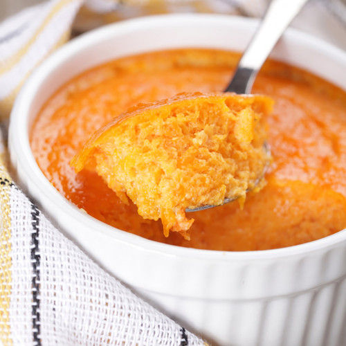 Spoonful of orange custard above a white ramekin — scent inspiration for Pumpkin Souffle fragrance oil
