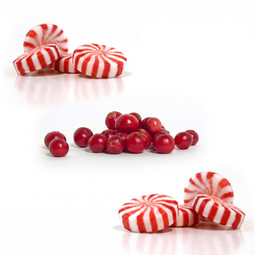 Red-and-white peppermint candies and cranberries on white — scent inspiration for Cranberry Peppermint fragrance oil