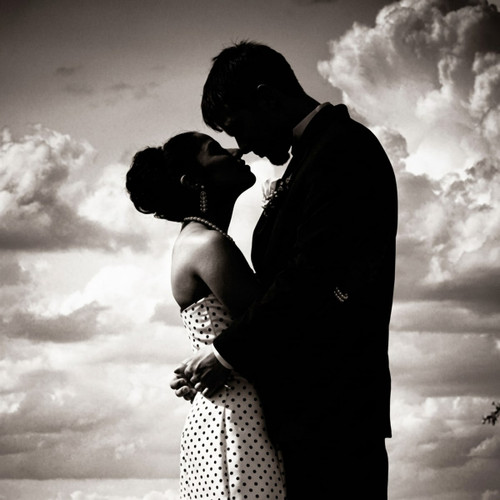 Black-and-white silhouette of a couple embracing under clouds — scent inspiration for Pure Seduction fragrance oil