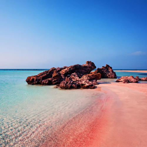 Pink-tinged sandy beach with rocks and turquoise water — scent inspiration for Pink Sands fragrance oil