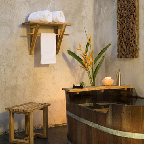 Wooden bath tub, towel rack, and salt lamp against stucco — scent inspiration for Teak Bamboo fragrance oil