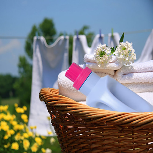 Detergent bottle and towels in a basket by a laundry line — scent inspiration for Downy April Fresh fragrance oil