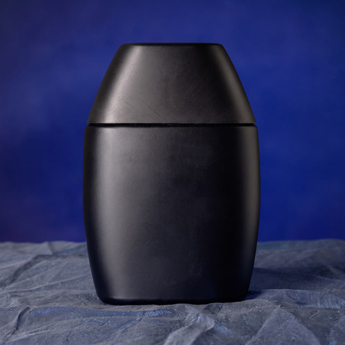 Matte black rounded jar on dark blue cloth — scent inspiration for Drakkar Noir fragrance oil