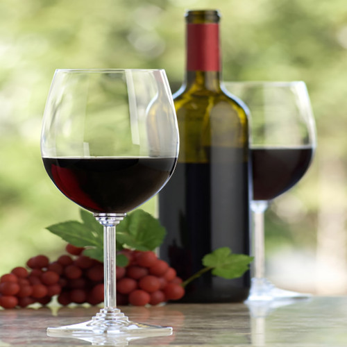 Two glasses of red wine with a bottle and grapes — scent inspiration for Merlot fragrance oil