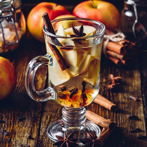 Spiced apple tea with cinnamon and star anise on dark wood — scent inspiration for Apple Chai fragrance oil