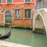 Gondola on a green canal by an orange building and bridge — scent inspiration for Venice Peach Bellini fragrance oil