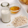 Milk bottle, dish of honey, and oats on a white tray — scent inspiration for Oatmeal, Milk & Honey fragrance oil