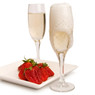Champagne flutes and red strawberries on a white plate — scent inspiration for Strawberries & Champagne fragrance oil