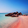 Pink-tinged sandy beach with rocks and turquoise water — scent inspiration for Pink Sands fragrance oil