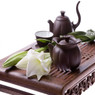 Brown clay teapot set with a white flower on a tray — scent inspiration for White Tea & Ginger fragrance oil