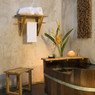 Wooden bath tub, towel rack, and salt lamp against stucco — scent inspiration for Teak Bamboo fragrance oil