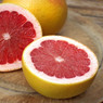 Halved pink grapefruit on a wooden board — scent inspiration for Pink Grapefruit fragrance oil
