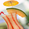 Creamy drink with a melon slice and orange umbrella — scent inspiration for Exotic fragrance oil