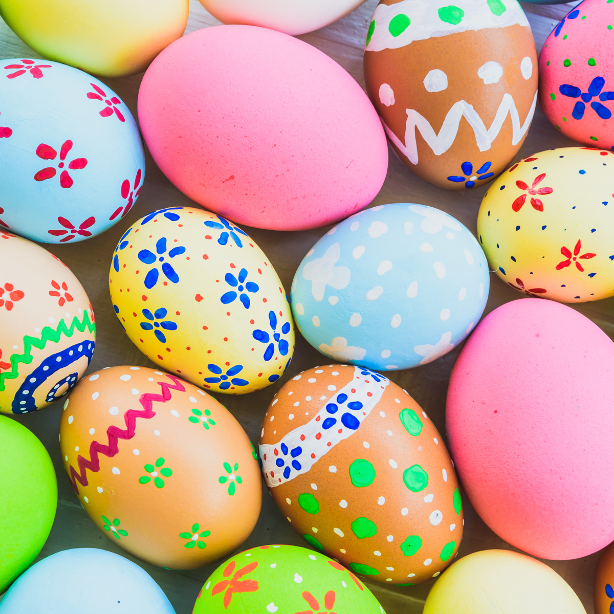 Soft pastel Easter-themed category image featuring decorated speckled eggs in light pink, blue, and yellow nestled in grass, with spring florals and a bright seasonal background.