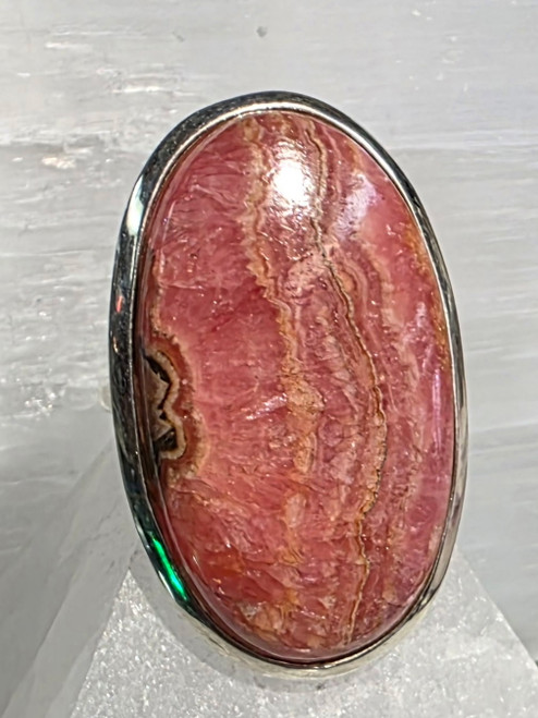 Ring Rhodochrosite Size 10.5
Set in Sterling Silver 
Stone size approx 3.5x2cm

Rhodochrosite - is known as a Stone of Love, Balance & Gratitude. Offering feelings of peace, love & joy. It is a powerful heart healing stone. Rhodochrosite aids in healing emotional wounds, especially if there has been past trauma surrounding love issues. It assists one in expressing love and affection. It can help one find the courage to pursue ones dreams. It helps to reawaken the heart and relieve painful emotional memories. It can bring out the child nature. It is cleansing, renewal, relaxation, expansion of consciousness. Used for Digestion, kidneys, thyroid, pulse rate, digestion. 
