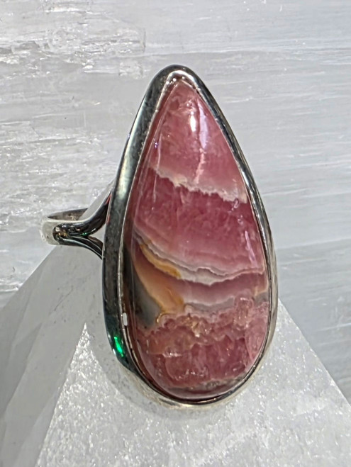 Ring Teardrop Rhodochrosite Size 11.5
Set in Sterling Silver 
Stone size approx 3x1.5cm

Rhodochrosite - is known as a Stone of Love, Balance & Gratitude. Offering feelings of peace, love & joy. It is a powerful heart healing stone. Rhodochrosite aids in healing emotional wounds, especially if there has been past trauma surrounding love issues. It assists one in expressing love and affection. It can help one find the courage to pursue ones dreams. It helps to reawaken the heart and relieve painful emotional memories. It can bring out the child nature. It is cleansing, renewal, relaxation, expansion of consciousness. Used for Digestion, kidneys, thyroid, pulse rate, digestion. 
