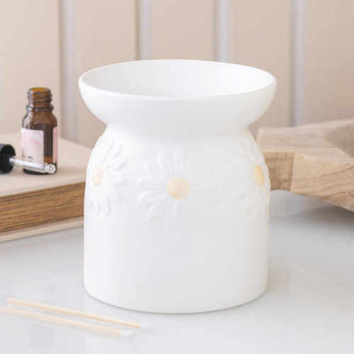 Oil Burner Daisy Chain
Enhance any space with this elegant white ceramic oil burner, adorned with a delicate daisy design for a fresh floral aesthetic. Ideal for gifting to fragrance enthusiasts or as a cheerful addition to your home decor. For optimal use, pair with fragrance oil diluted in water. This piece is part of the Classic Oil Burners collection, offering a range of home fragrance gifts and decorative items.

Product Dimensions: H12.5cm x W11.5cm x D11.5cm