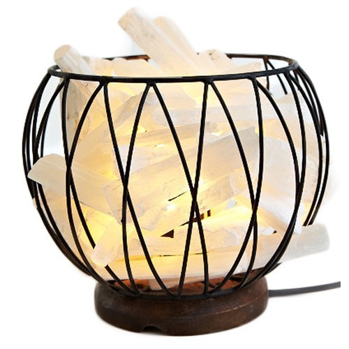Selenite Caged Lamp

Selenite 'Stalagmite' Caged Fire Bowl Comes with cord & Globe Selenite is a calm stone that In stills deep peace and is excellent for meditation or spiritual work. Selenite is a type of gypsum crystal that is often translucent or a shimmering opaque. Our selenite products come from the ancient sea beds in Morocco. The purest translucent white selenite is said to have an ethereal quality, inhabiting the space between light and matter. The very fine vibration of selenite brings clarity of mind. Its high frequency vibration qualities link it to the light body, helping to anchor it to the earths vibrations. This versatile and often underrated crystal has properties that make it truly unique for spiritual and metaphysical purposes