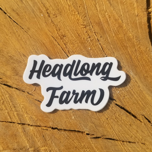 A small wordmark sticker against a piece of wood