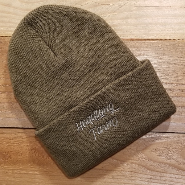 An olive beanie embroidered with the Headlong Farm brand and a generous cuff