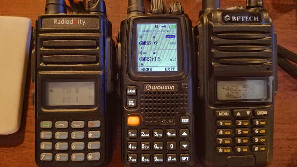 Three handheld two-way radios, side-by-side, showing customizations on their screens.