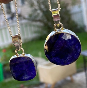 A meticulously crafted necklace featuring a deep blue sapphire encased in sterling silver, designed to channel healing energies. A meticulously crafted necklace featuring a deep blue sapphire encased in sterling silver, designed to channel healing energies.