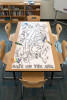 Classroom table with Noah’s Ark flood coloring table runner showing rain and ark floating on water for a kids Sunday school Bible activity.