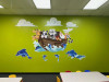 Noahs Ark classroom wall decal installed on green wall with tables and chairs.