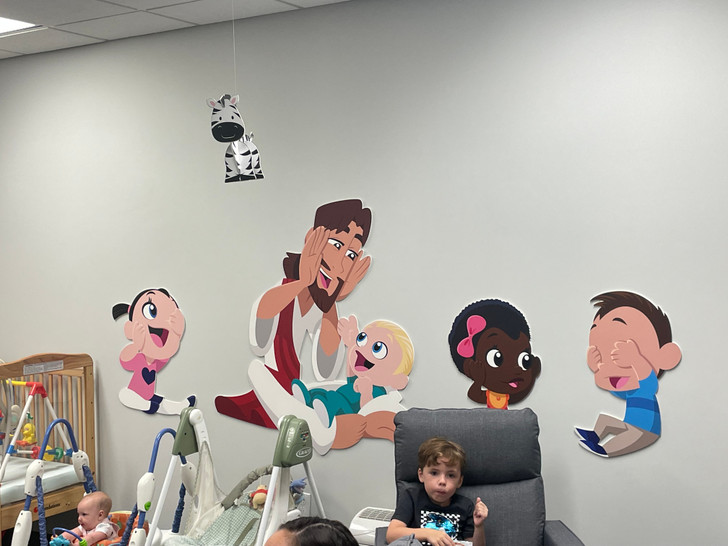 Christian wall decal of Jesus with a baby for church nursery or preschool classroom.