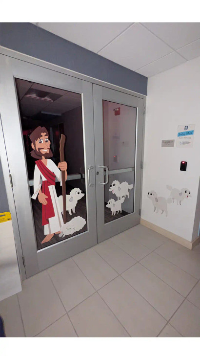 Good Shepherd wall decal with Jesus and lambs applied to classroom glass doors.
