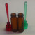 SET OF 2 - AMBER GLASS BULLET JARS WITH LIDDED COLORED PLASTIC SPOON
