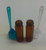 SET OF 2 - AMBER GLASS BULLET JARS WITH LIDDED COLORED PLASTIC SPOON