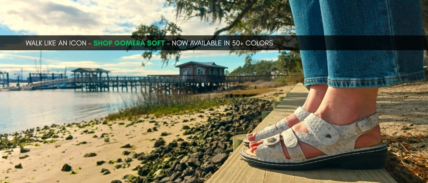 Image of Finn Comfort new Women's Gomera Soft sandal in Bianco Esandra color taken standing on the South Carolica shore and text 'Walk like an icon - Shop Gomera Soft - Now available in 50+ colors' on image
