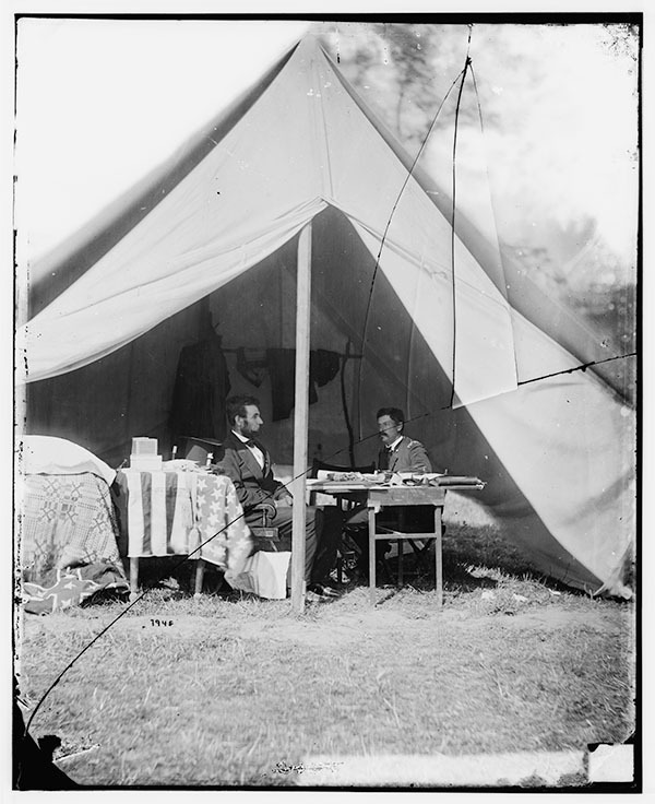 President Abraham Lincoln and General George B. McClellan seated inside a tent at Antietam