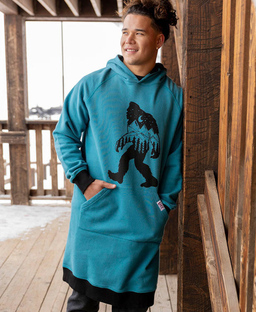 man leaning against wood pillar wearing a Bigfoot Sleep hoodie in blue
