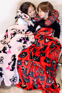 two kids wrapped in travel blankets