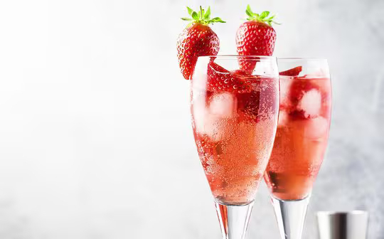 a glassed filled with strawberry wine punch and garnished with a fresh strawberry