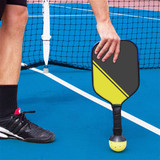 The Pickle-Upper Ball Pickup Tool fits over pretty much any paddle handle and allows you to pick up balls without fully bending over and straining your back or knees. It's a suction cup on the end of your paddle handle.