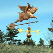 Flying Pig Weathervane on blue sky background.
