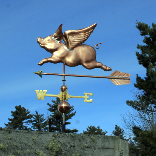 Flying Pig Weathervane left side view on blue sky background.