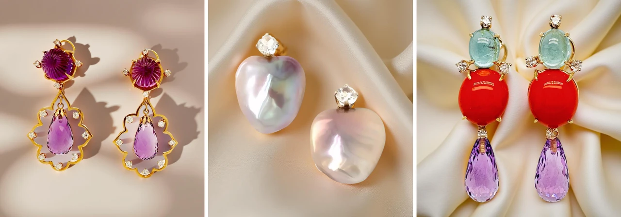 Trio of luxurious drop earrings with gemstones — amethyst and ruby carved earrings in gold, iridescent heart-shaped pearl studs with diamonds, and bold aquamarine-red amethyst statement earrings — displayed on satin backdrop.